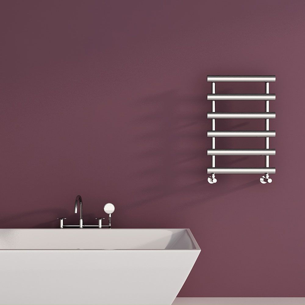 Bathroom with a white freestanding bathtub and a metal towel radiator on a purple wall.